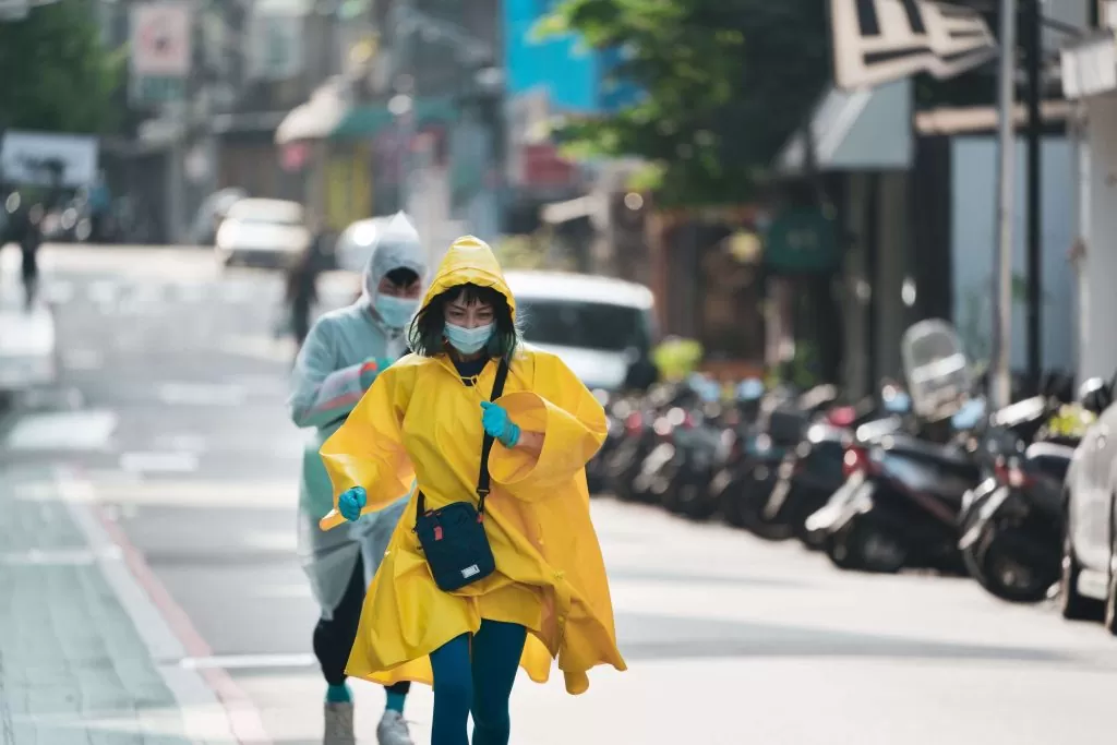 two people in cleaning suits running down the street